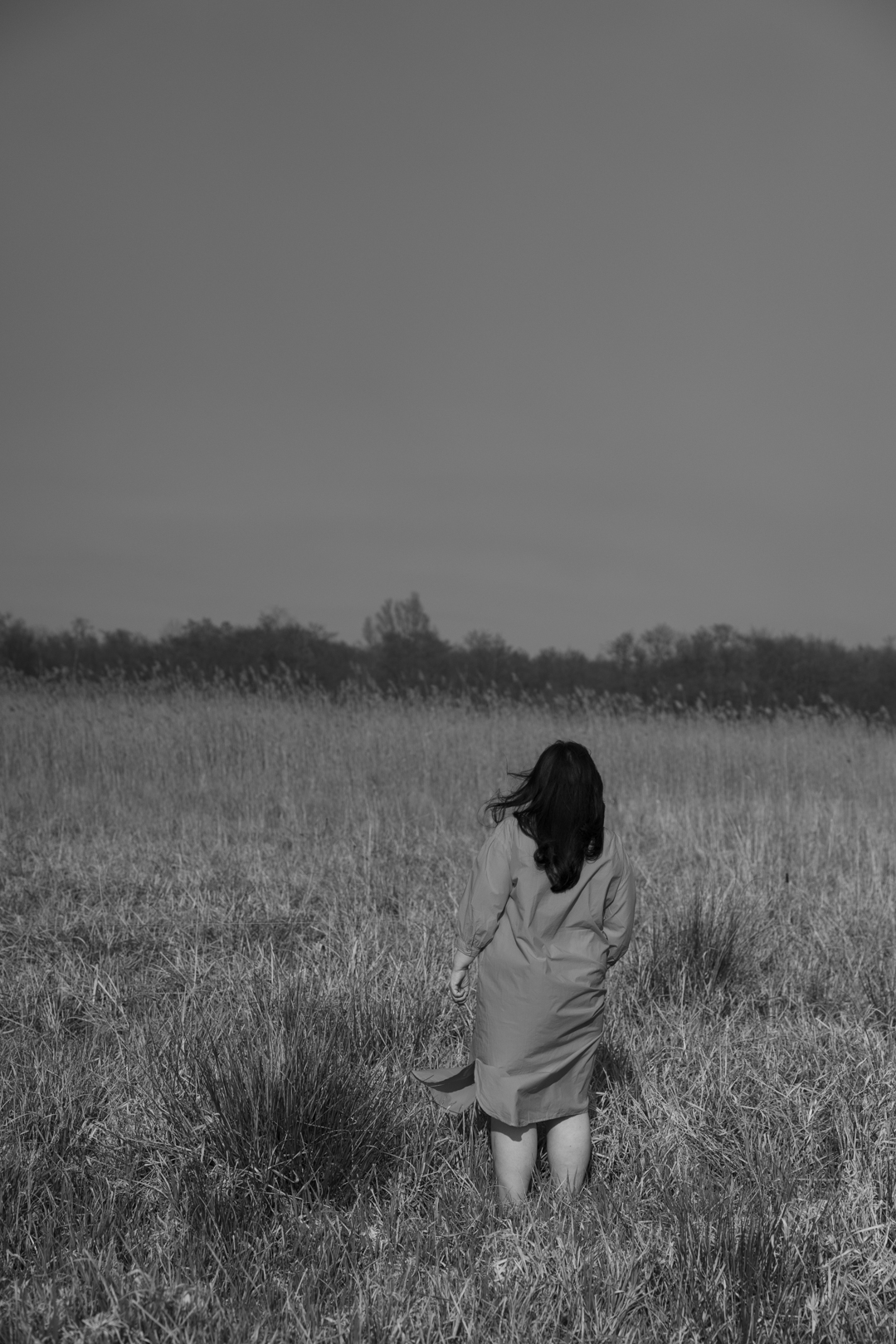 Vrouw staand in een veld, zwart-wit